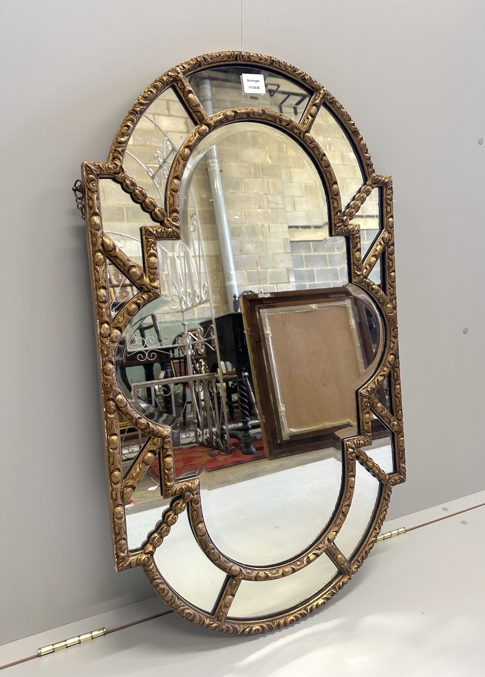 A Victorian carved giltwood and gesso shaped oval mirror, with marginal plates, width 57cm, height 100cm